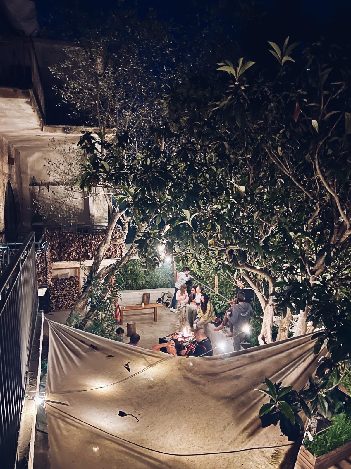 Aro at night, lit by lamps, with people gathered